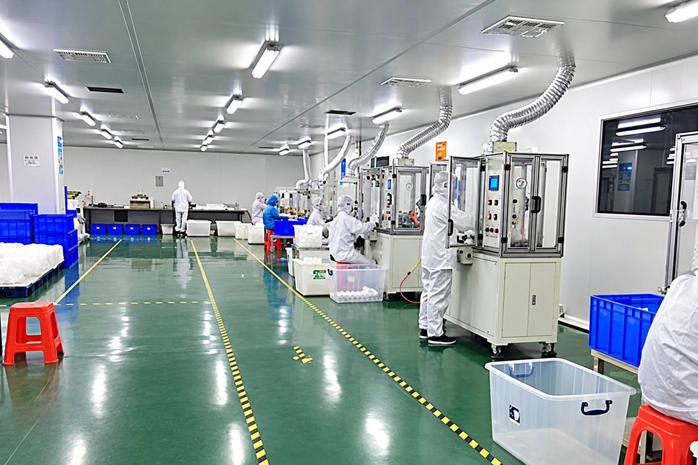 MedIntegrity cleanroom production line — operators in cleanroom suits running automated assembly and testing stations for pharmaceutical instruments